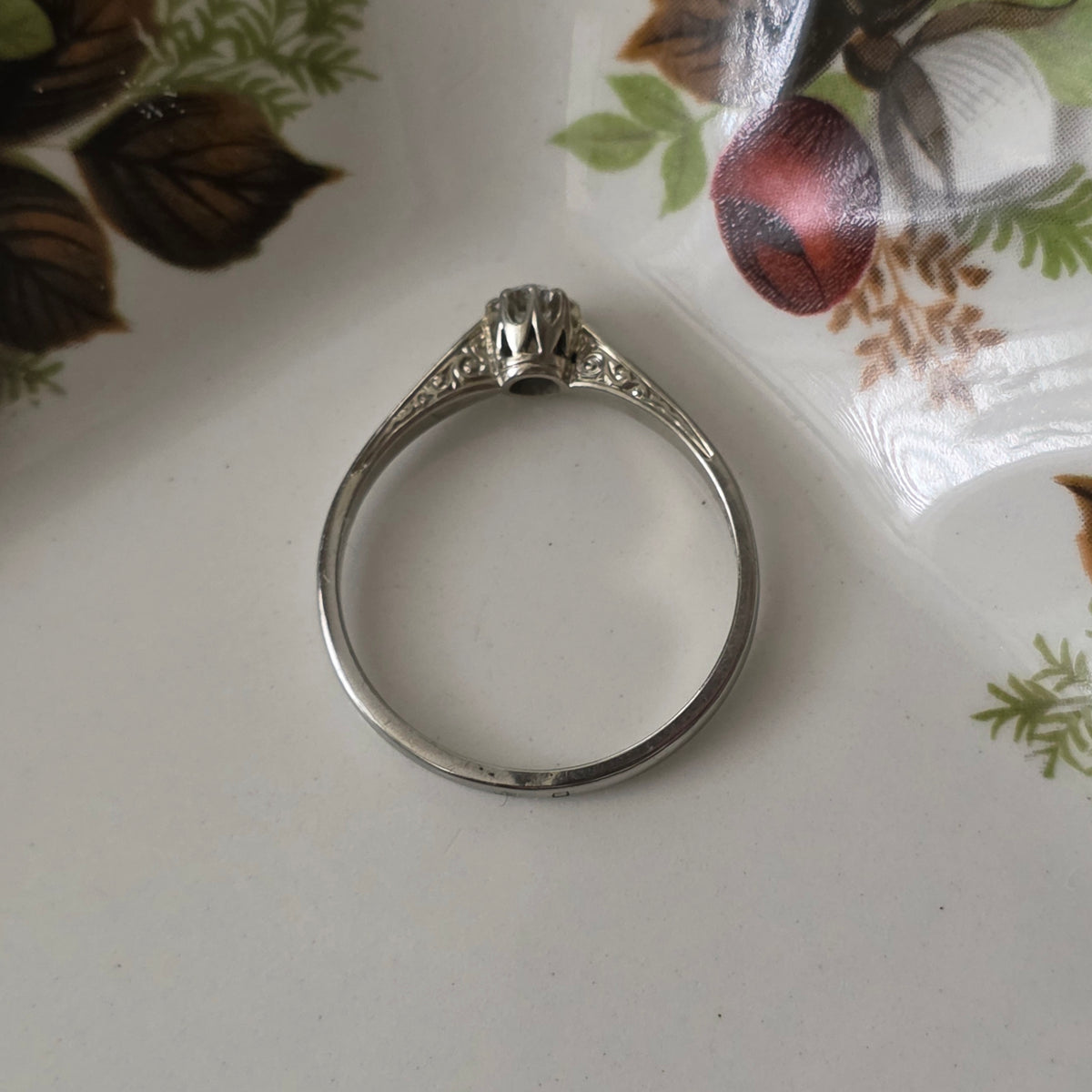 Vintage 18k white gold engagement ring with engravings and a 0.1ct solitaire diamond.