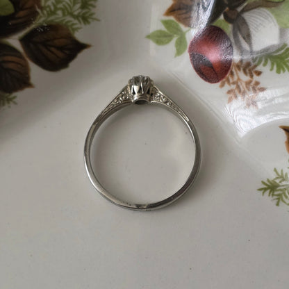 Vintage 18k white gold engagement ring with engravings and a 0.1ct solitaire diamond.