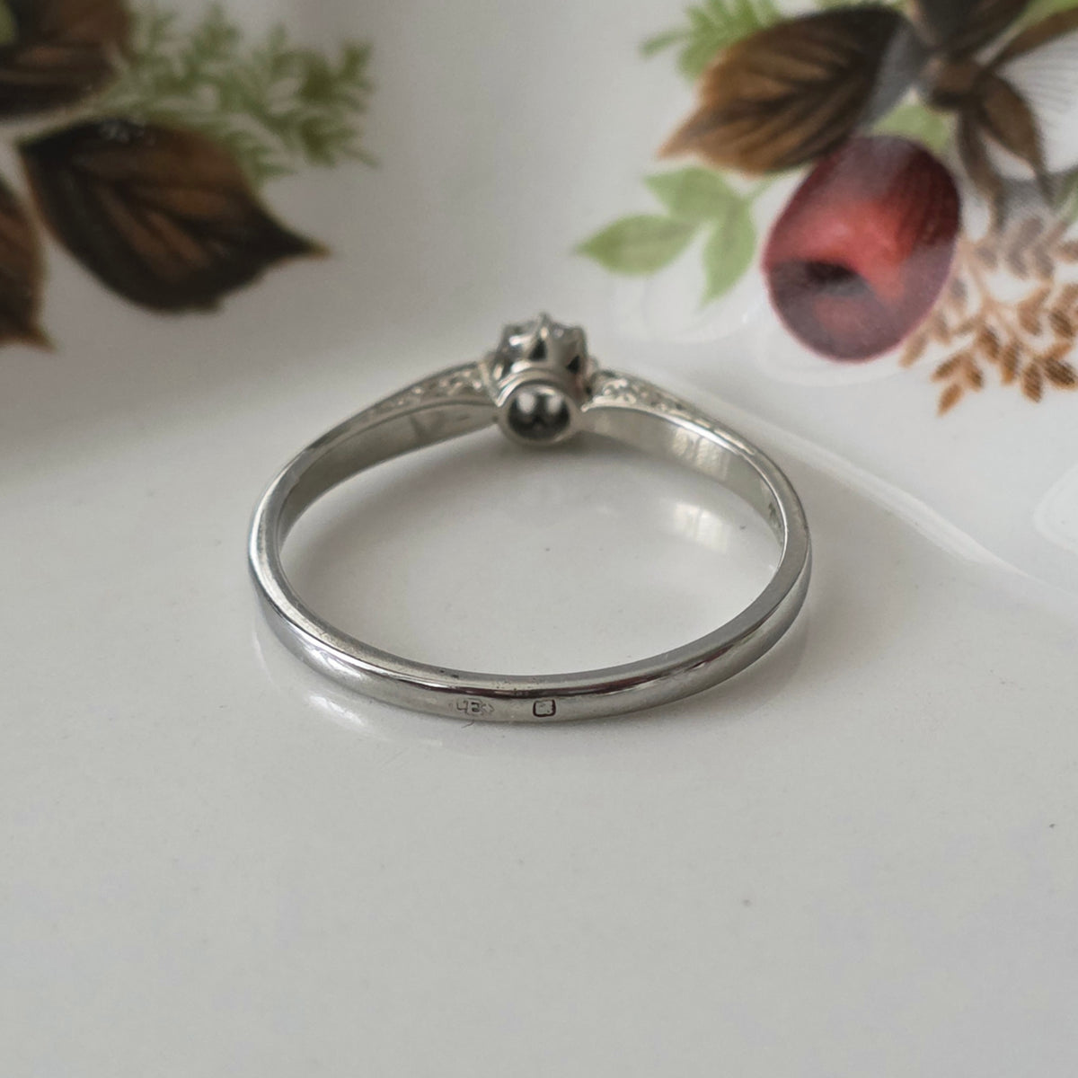 Vintage 18k white gold engagement ring with engravings and a 0.1ct solitaire diamond.