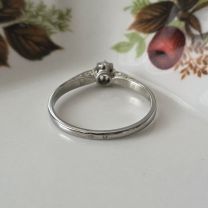 Vintage 18k white gold engagement ring with engravings and a 0.1ct solitaire diamond.