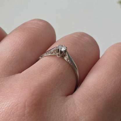 Vintage 18k white gold engagement ring with engravings and a 0.1ct solitaire diamond.