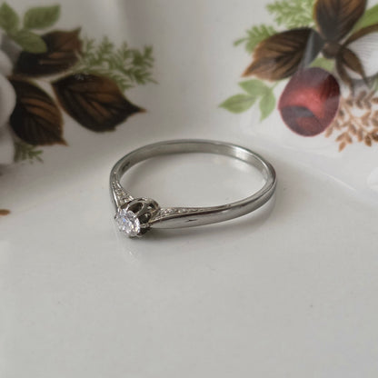 Vintage 18k white gold engagement ring with engravings and a 0.1ct solitaire diamond.