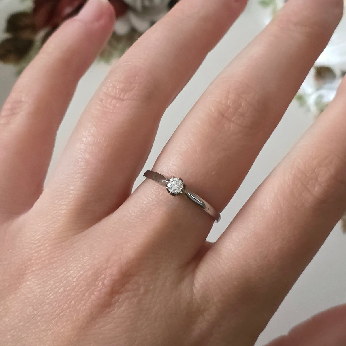 Vintage 18k white gold engagement ring with engravings and a 0.1ct solitaire diamond.