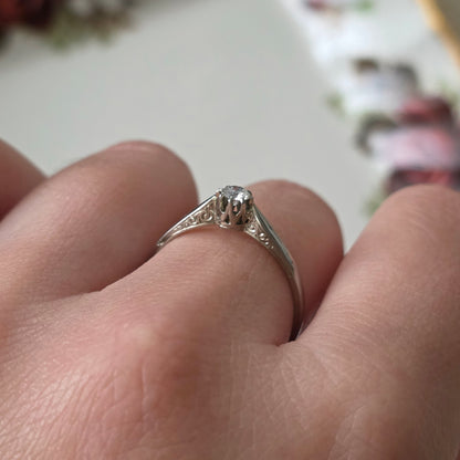 Vintage 18k white gold engagement ring with engravings and a 0.1ct solitaire diamond.