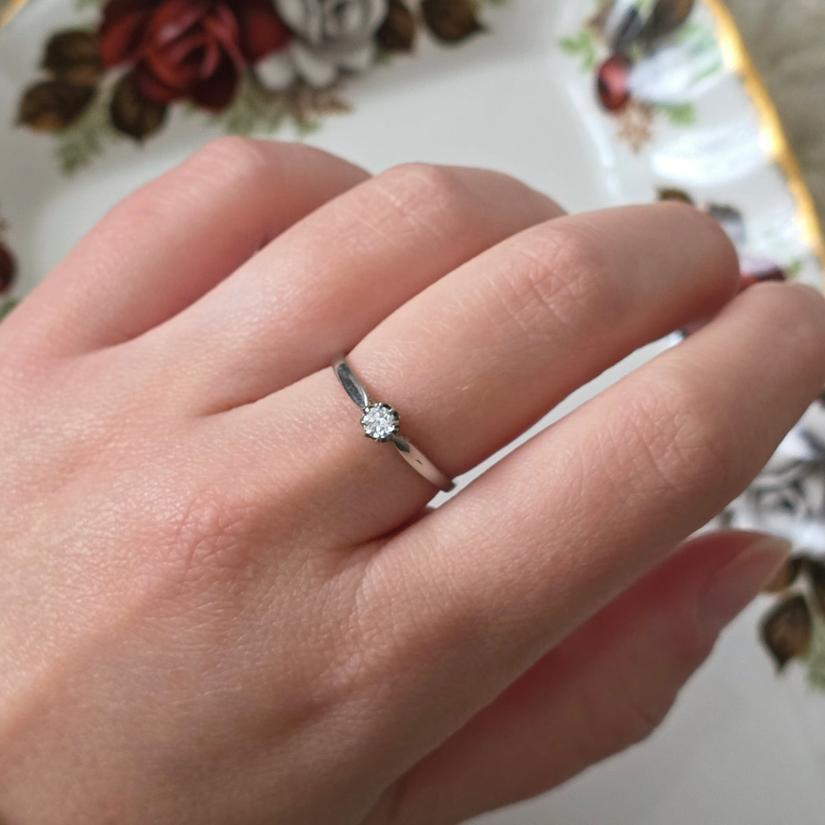 Vintage 18k white gold engagement ring with engravings and a 0.1ct solitaire diamond.