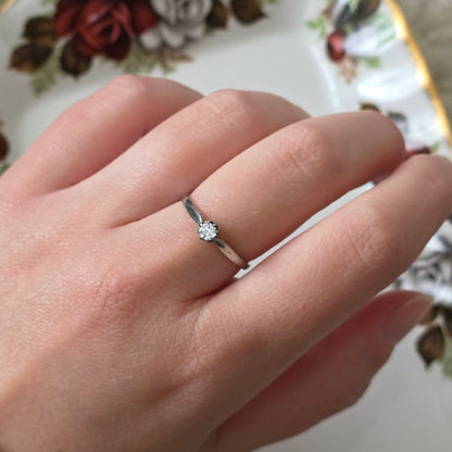 Vintage 18k white gold engagement ring with engravings and a 0.1ct solitaire diamond.